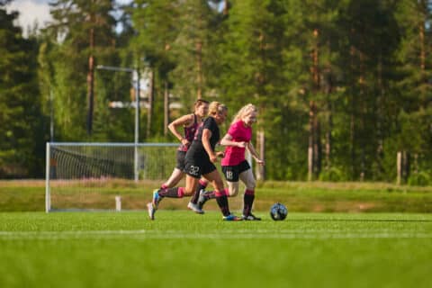 Naiset pelaavat jalkapalloa Kuhmon urheilukentällä